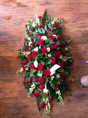 Red, white and green casket spray.